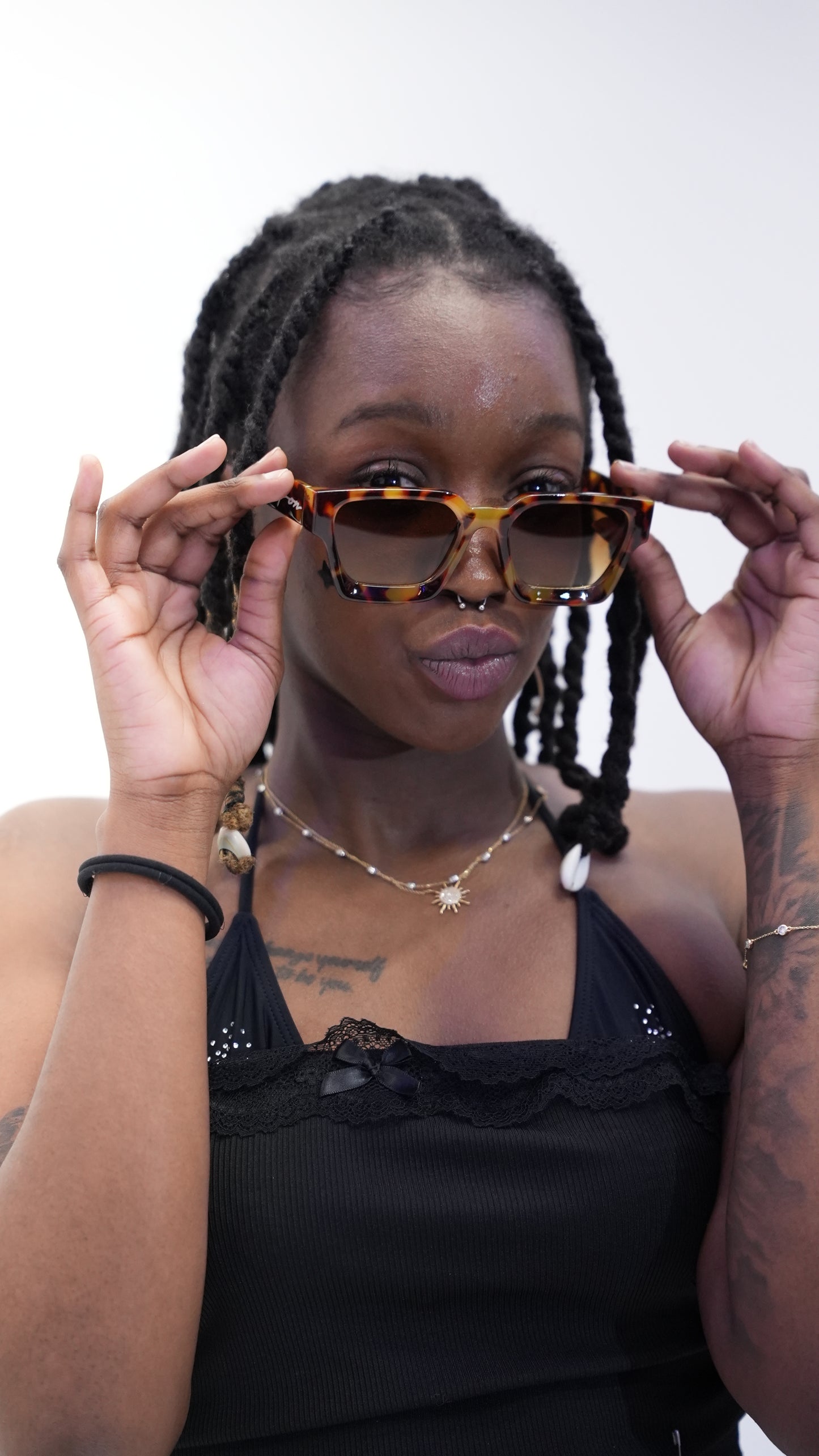 Dark skin woman wearing Ison Couture Tigers Eye tortoise bold square sunglasses