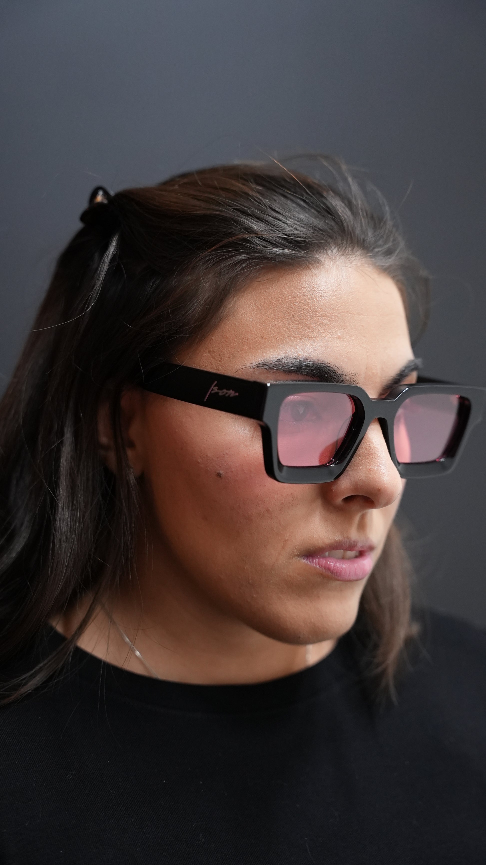 Person wearing Ison Couture black and Red lens square polarized sunglasses
