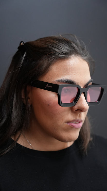 Person wearing Ison Couture black and Red lens square polarized sunglasses