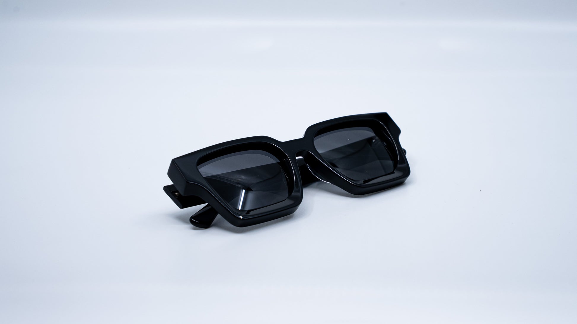 Ison Couture Polar Black polarized sunglasses folded on white background