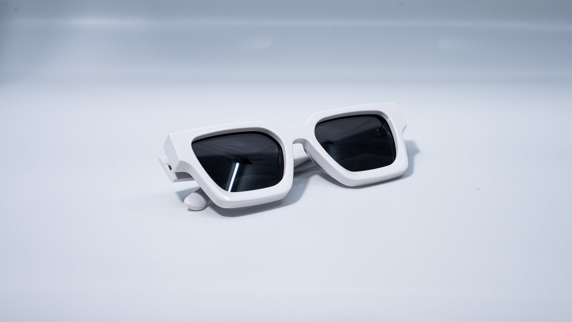 Ison Couture Polar White polarized sunglasses folded on white background
