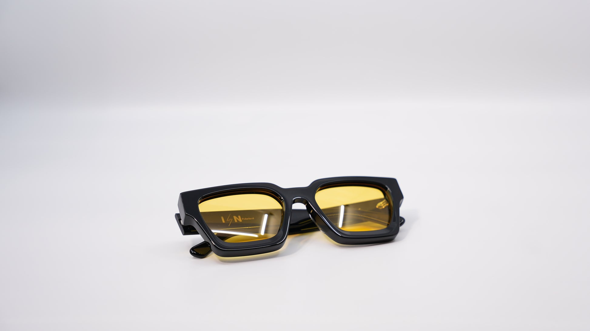 Ison Couture Sunrise polarized sunglasses folded showing yellow lens detail