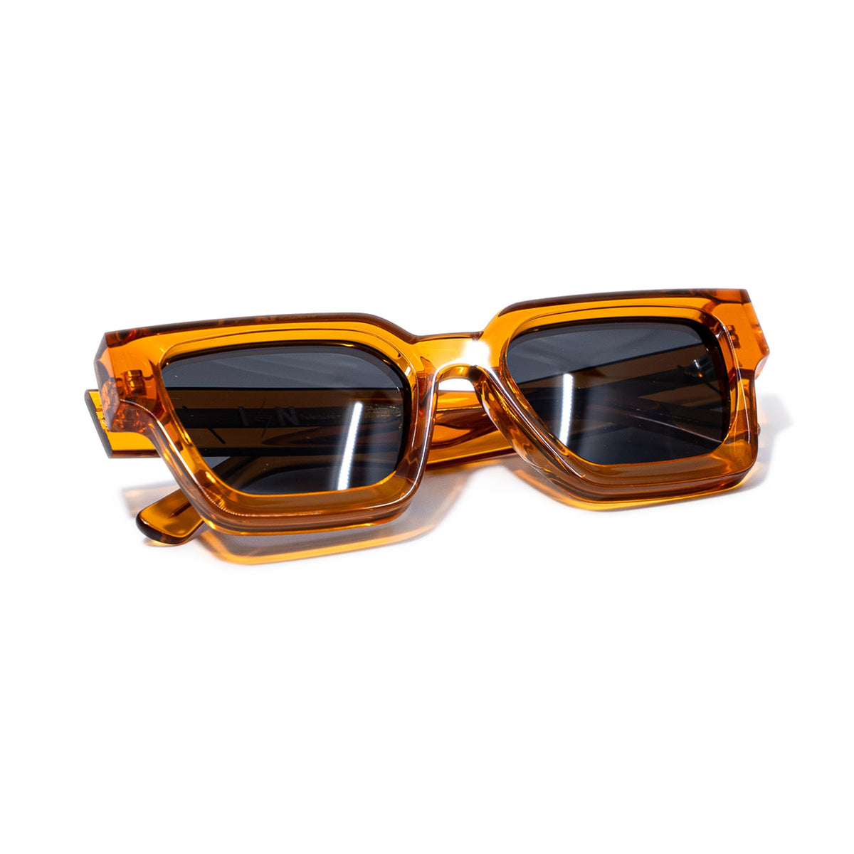 Citrus sunglasses folded, showing the translucent citrus orange bio-acetate glowing along the frame edges