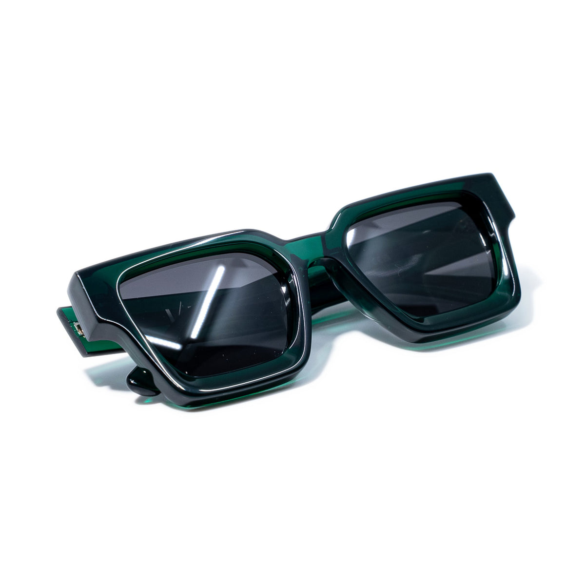 Emerald Green sunglasses folded, showing the jewel green bio-acetate glowing along the frame edges