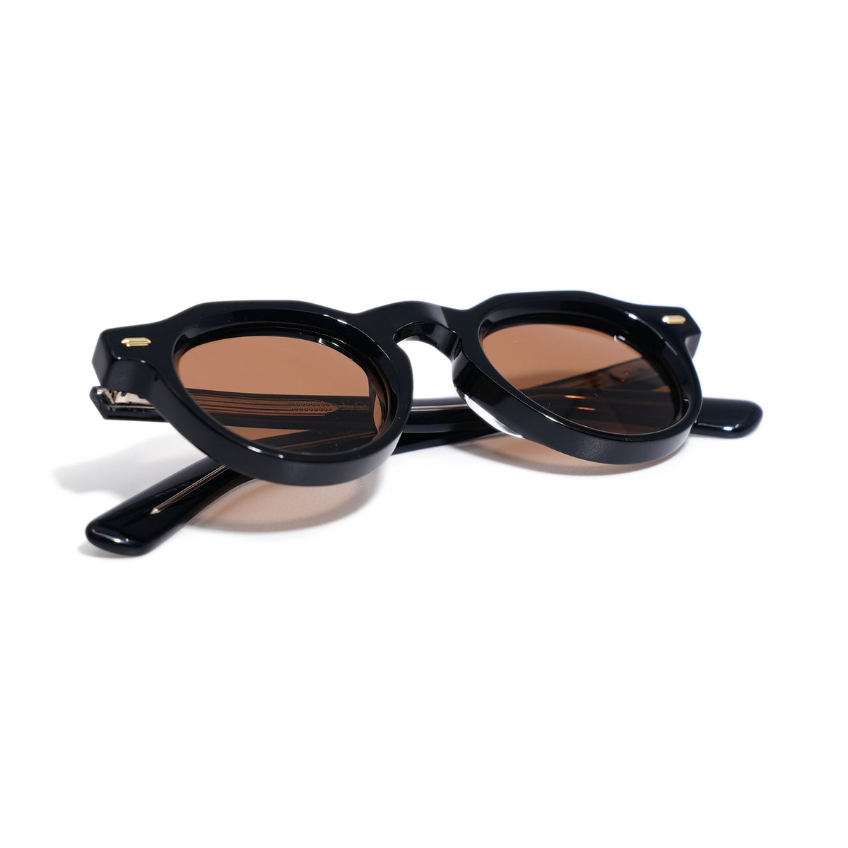 Round Black & Gold sunglasses folded, showing gloss black acetate and gold rivets at the hinges