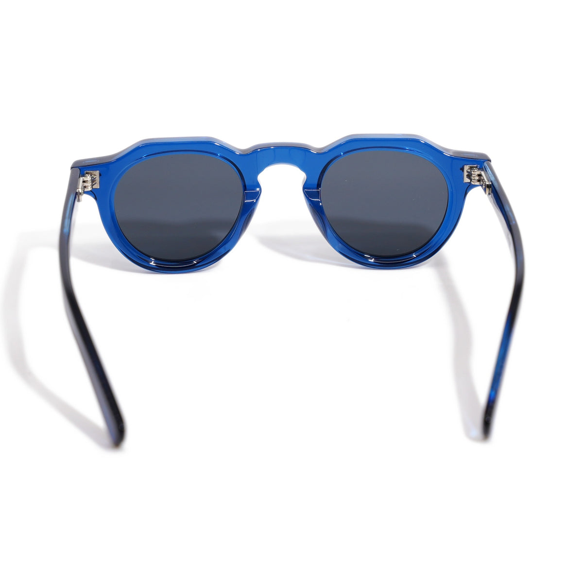 Round & Cobalt back view showing translucent blue acetate, silver hinge hardware, and smoke gray polarized lenses